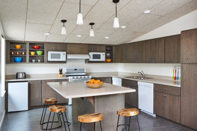 communal kitchen with dark wood cabinets and an island