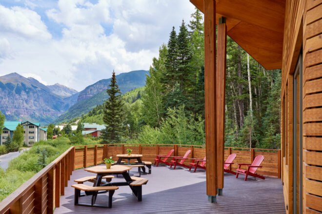wood deck with patio tables and red lounge chairs