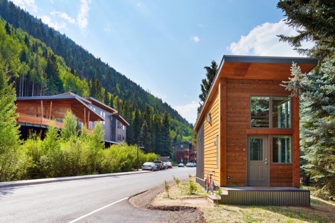 wooden tiny home beside a quiet road
