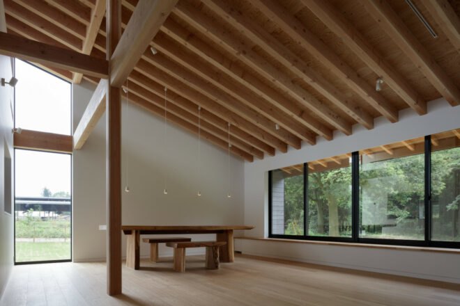 minimalist interior space with exposed beams on pitched roof