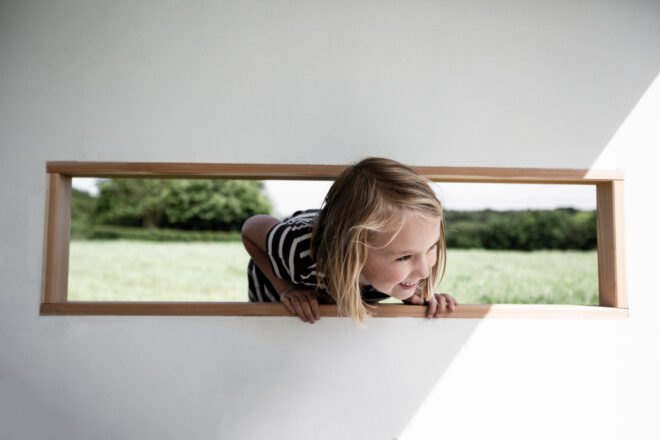 girl sticking her head out of a horizontal window
