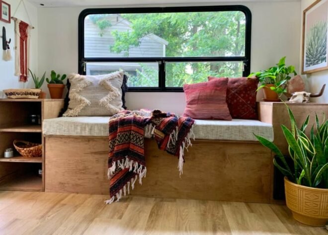 a bench in front of a window with multi-colored pillows