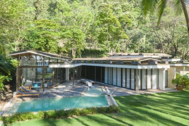pool outside of a beach house with glass walls