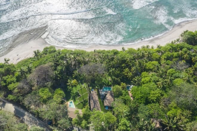 aerial view of homes with green roofs in front of a beach