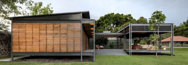 prefabricated wood home in a u shape with stairs surrounded by grass and trees