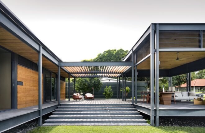 prefabricated wood home in a u shape with stairs surrounded by grass and trees