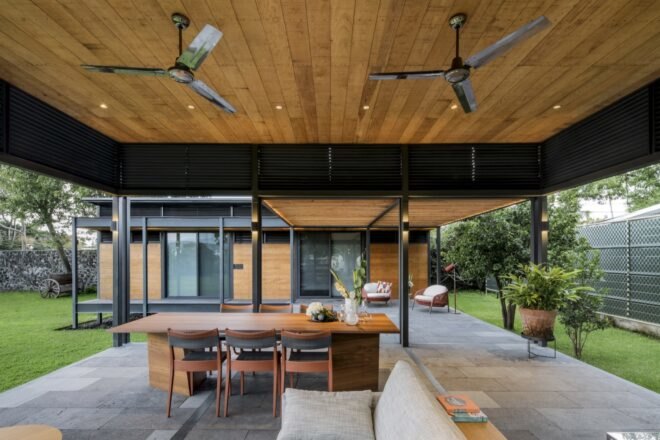 a wooden terrace over a wooden table with wood chairs and creme colored couches