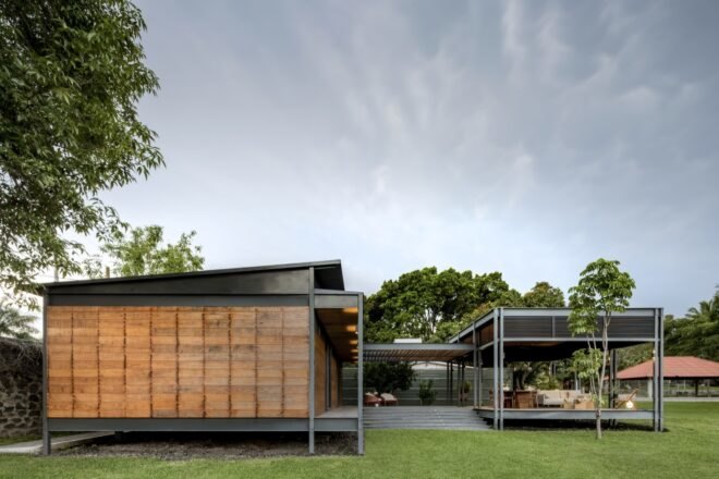 prefabricated wood home in a u shape with stairs surrounded by grass and trees