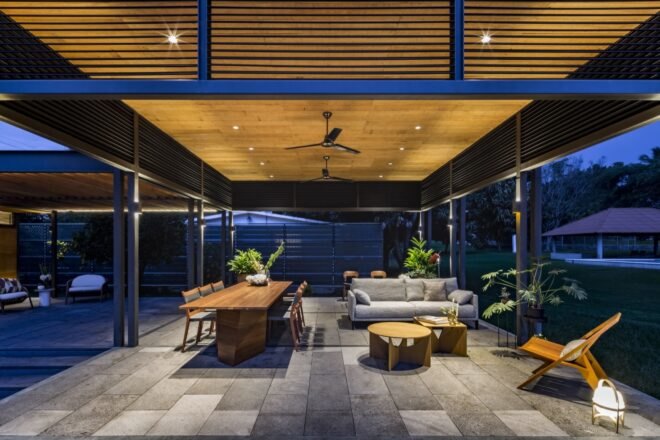 a wooden terrace over a wooden table with wood chairs and creme colored couches