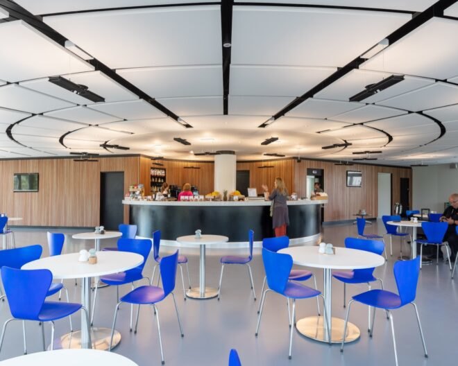 blue chairs surround white tables with white ceilings with lights