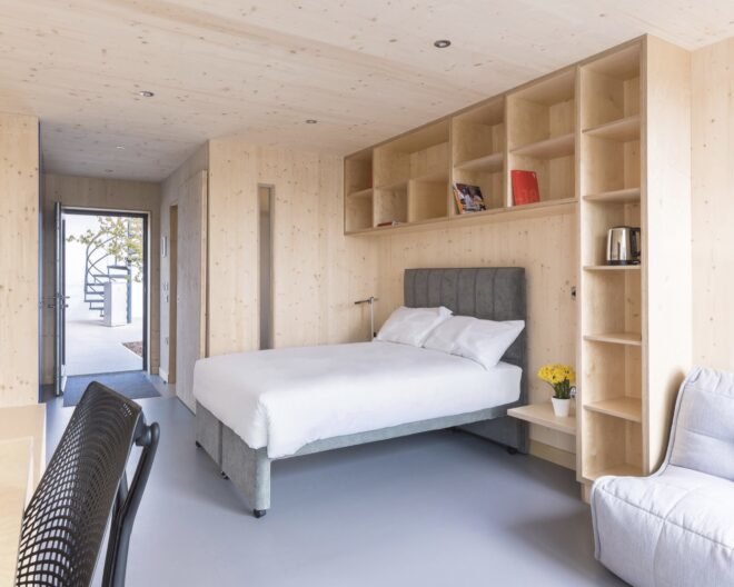 dormitory inside building with a bookcase surrounding a bed