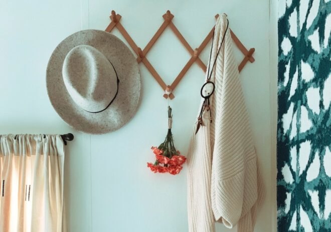 a wall rack with a hat and sweater hanging on it