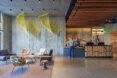 hotel lobby with lounge chairs, bar and hanging art