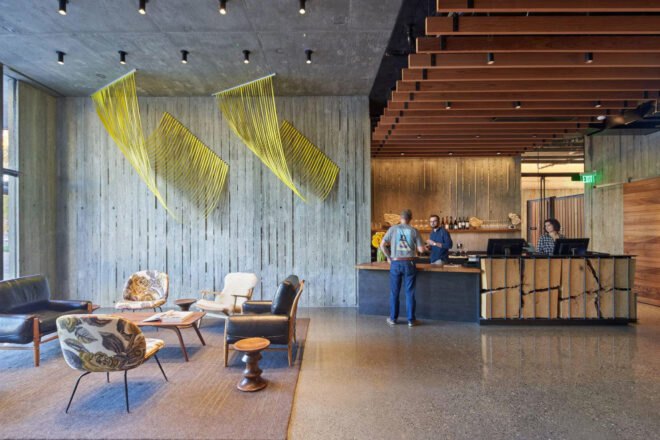 hotel lobby with lounge chairs, bar and hanging art