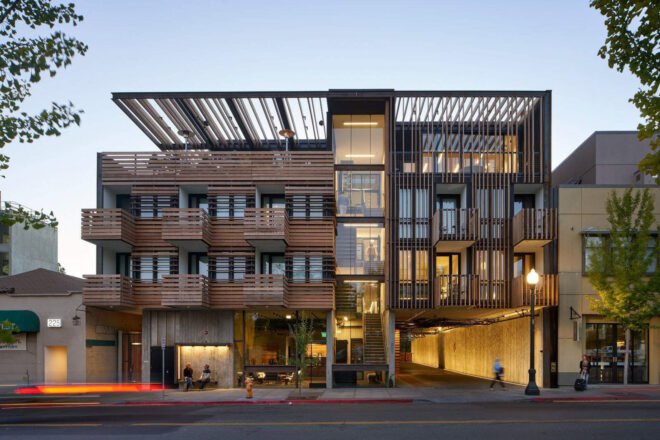 wood and glass hotel building lit up at night