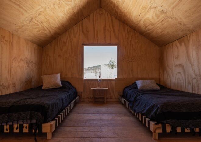 two beds and a window in lofted sleeping area