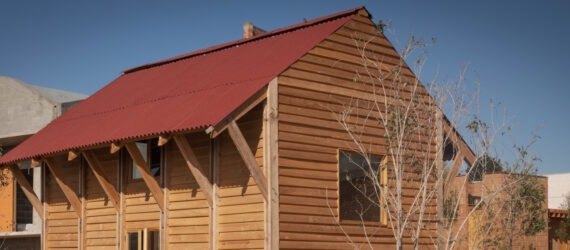 small timber home with red gabled roof