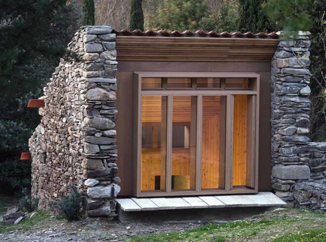 small wood and stone building surrounded by trees