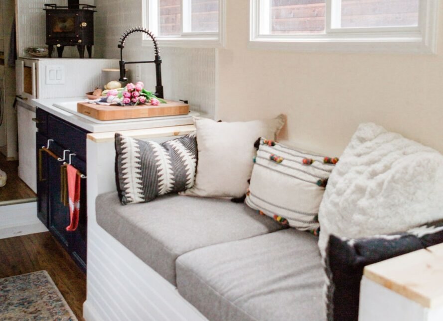 a small loveseat next to a kitchen area