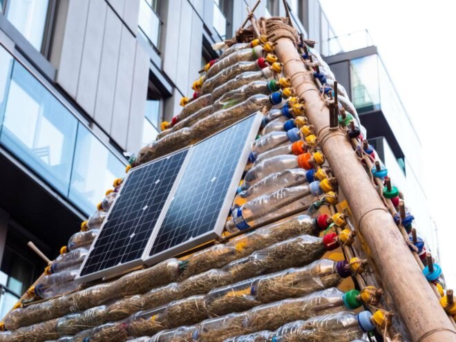solar panels on outside of shelter made from plastic bottles