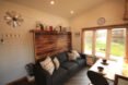 inteiror of tiny home with wooden accent wall behind a black sofa