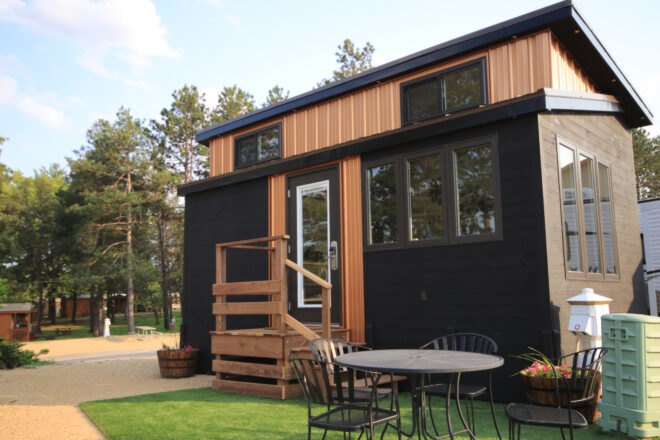 black and tan tiny home with windows and front stairwell