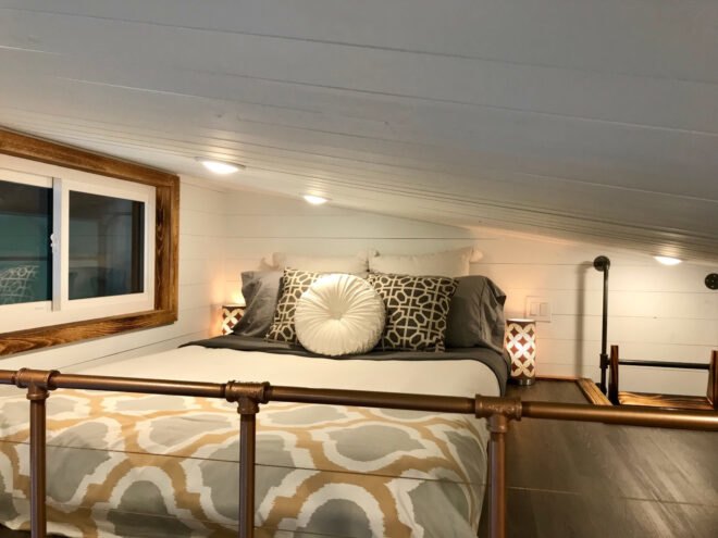 loft with queen-sized bed and slanted roof