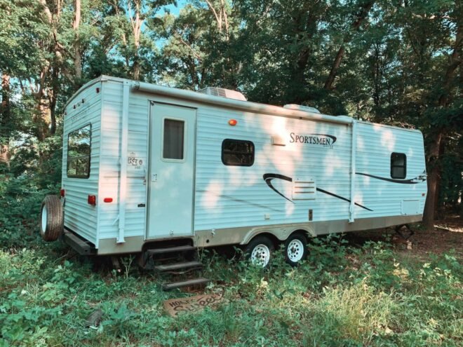 white camper on grassy lot