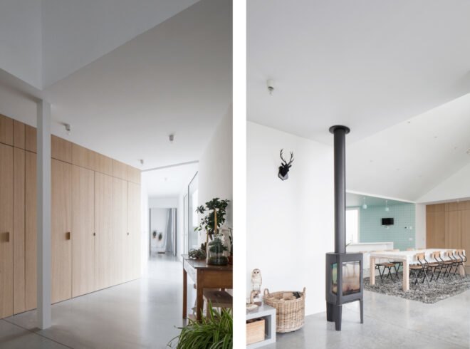 white walls and floor are illuminated with natural light from large nearby windows with a fireplace in living area
