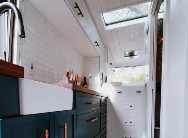kitchen space with dark blue cabinets and white tiles
