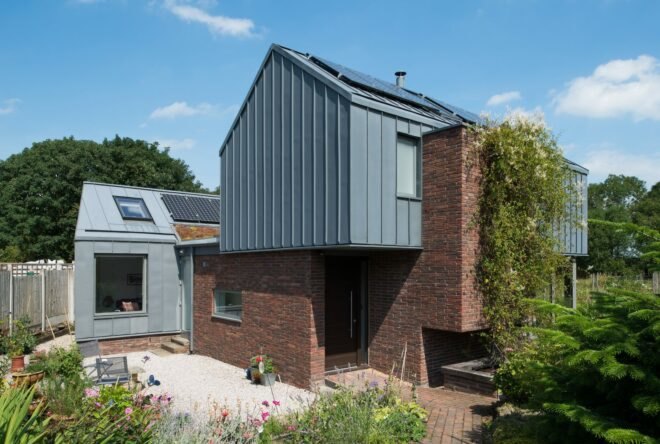 brick home with zinc roof topped with solar panels