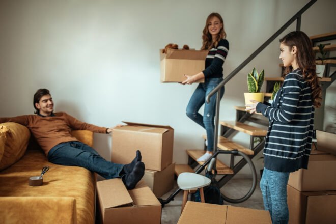 group of people moving boxes in new apartment