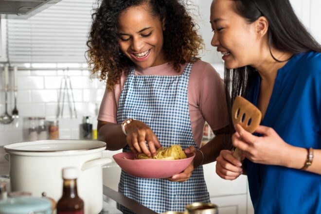 two friends cooking dinner together