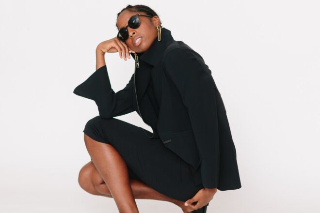 model wearing black jacket and black skirt