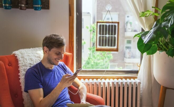 man sitting next to window with framed solar panels
