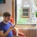 man sitting next to window with framed solar panels