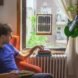 man sitting next to window with framed solar panels
