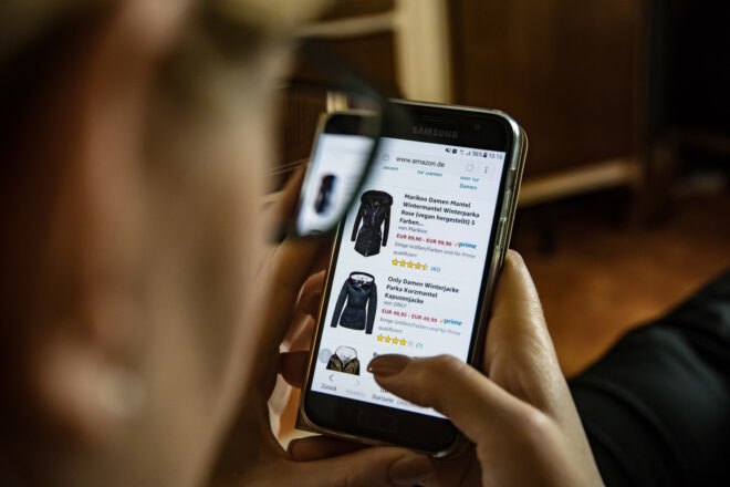 person holding cell phone while online shopping