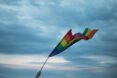 rainbow flag waving against cloudy skies