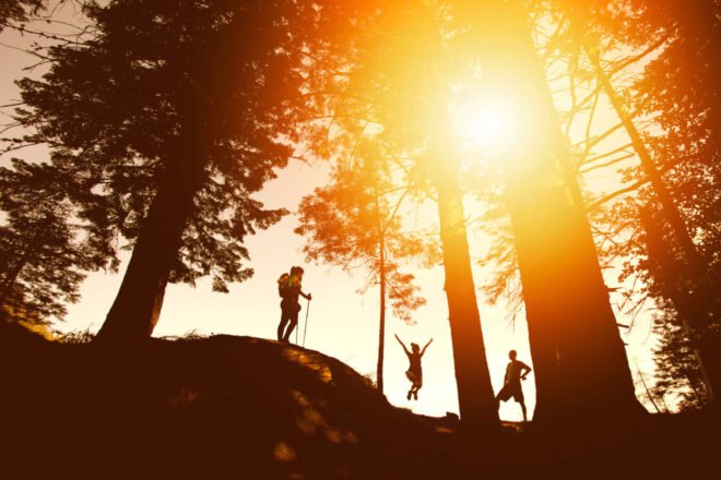 silhouettes of people hiking at sunset