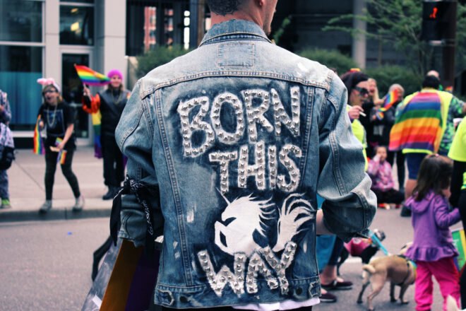person at Pride parade wearing DIY decorated jacket that reads "Born This Way"