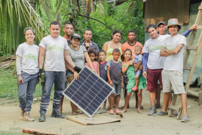 Tierra Grata members and community holding a solar panel
