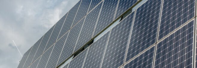 solar panels with blue cloudy sky in background