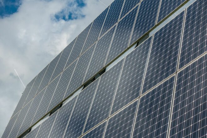 solar panels with blue cloudy sky in background