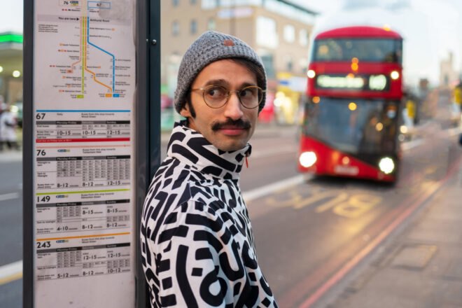 person in black and white patterned jacket in a city