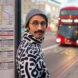 person in black and white patterned jacket in a city