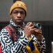 person in black and white patterned jacket and taking photos