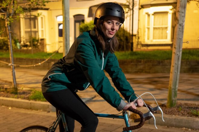 person wearing teal jacket and helmet while riding a bike