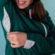 person unzipping armpit pocket in a teal jacket