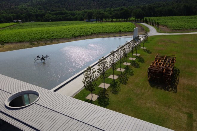 spider art in the middle of a lake lined with trees